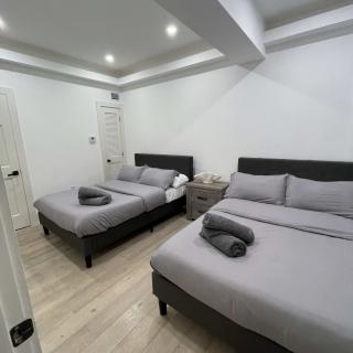 A modern and minimalist bedroom featuring two neatly made beds with gray bedding.