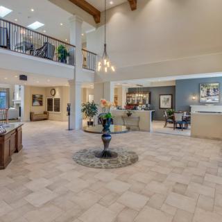 A spacious and elegantly decorated lobby area with modern furnishings and a central table feature.