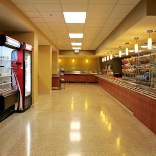 A spacious interior of an ice cream parlor featuring modern design elements and various food displays.