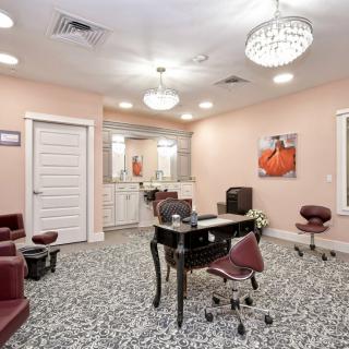 A modern salon interior with elegant furnishings and a stylish chandelier.