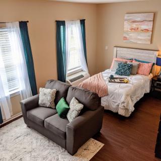 A cozy bedroom with a neatly made bed and a comfortable sofa.