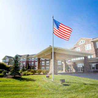 A sunny day with an American flag waving in front of a large building.