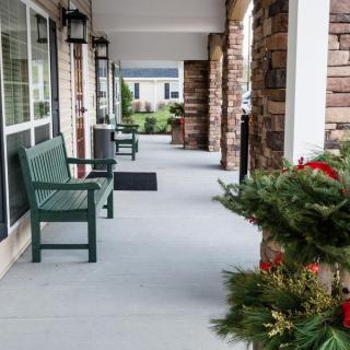A welcoming porch with benches and seasonal decorations.