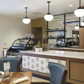 A modern cafe interior with seating and a display counter.
