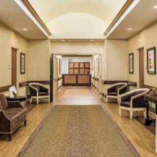 A well-lit hallway with seating options, leading to a main entrance.