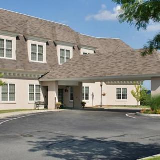 Exterior view of a building with a driveway and landscaped surroundings.