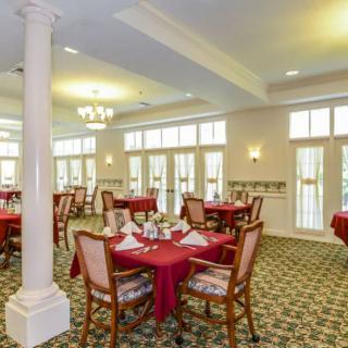A formal dining room with elegantly set tables and chairs, featuring a classic interior design.