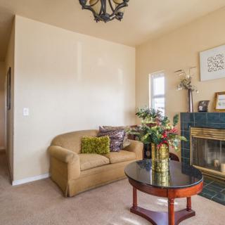 A cozy living room with a couch, coffee table, and decorative fireplace.
