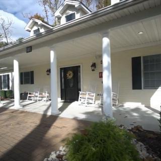 A welcoming porch with white columns and rocking chairs in front of a house.