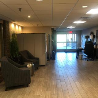 A spacious and well-lit lobby featuring comfortable seating and access to the outdoors.