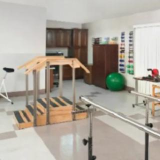A rehabilitation room equipped with various physical therapy tools and exercise equipment.
