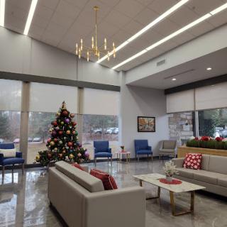 A modern lobby decorated for the holidays, featuring a beautifully adorned Christmas tree.