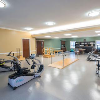 A spacious rehabilitation gym equipped with various exercise machines and rehabilitation tools.