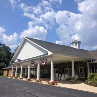 A charming building with a welcoming front entrance, complemented by a beautiful sky filled with clouds.
