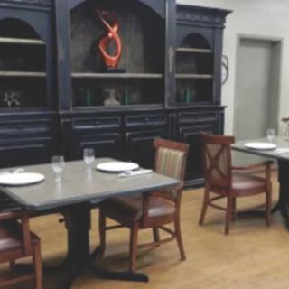 A restaurant dining area with neatly arranged tables and chairs, featuring elegant decor.