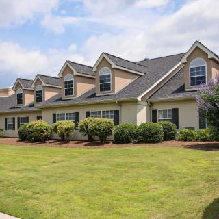 A row of suburban townhouses with a well-manicured lawn.
