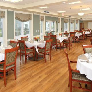 A spacious and well-lit dining area featuring elegantly set tables and comfortable seating.
