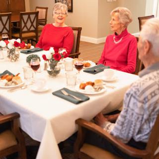 A cheerful dining scene with seniors enjoying a meal together at a beautifully set table.