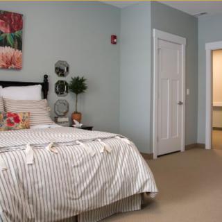 A cozy and minimalist bedroom with a neatly made bed and simple decor.