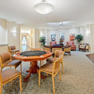 A well-lit, inviting interior space with a dining table and chairs arranged for communal activities.