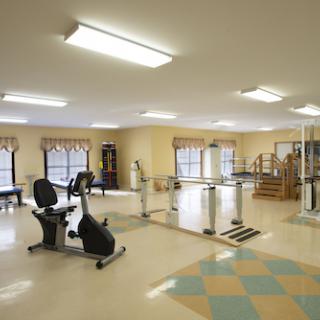 A spacious gym area equipped with various fitness machines, perfect for exercise and rehabilitation.