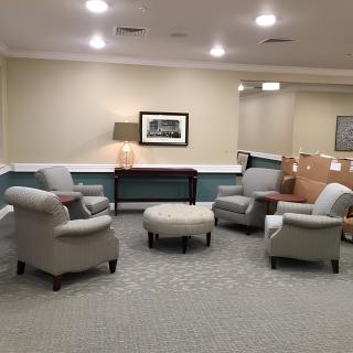 A cozy lobby area with armchairs arranged around a central table.