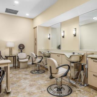 A well-lit beauty salon with styling chairs and mirrors.