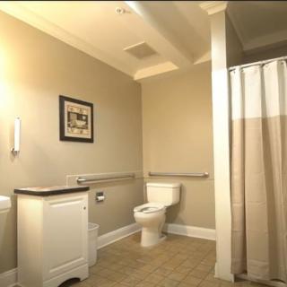 A clean and modern bathroom with a toilet, sink, and shower area.