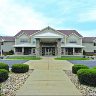 A well-designed building with a welcoming entrance surrounded by neatly landscaped greenery.