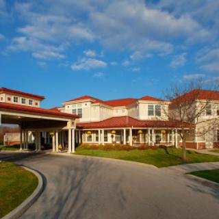 A modern senior living facility featuring a welcoming entrance and landscaped surroundings.