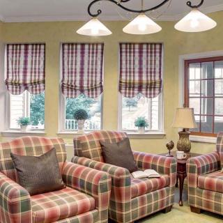 A cozy living room with plaid-patterned armchairs and matching curtains.