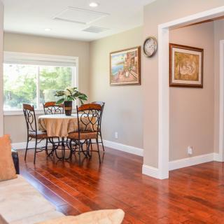 A cozy dining area with a round table, surrounded by chairs and illuminated by natural light from the window.