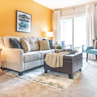 A cozy and stylish living room with a beige sofa, vibrant yellow walls, and elegant decor.