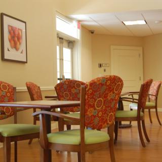 A well-lit seating area with decorative chairs and tables.