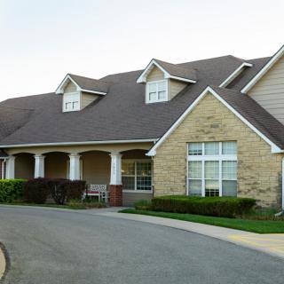 A large residential house with a driveway and well-maintained front yard.