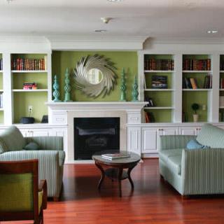 A cozy living room featuring a fireplace, bookshelves, and comfortable seating.