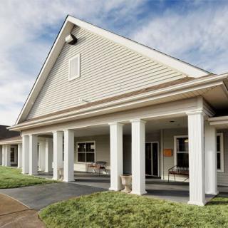 A residential building with a porch supported by white columns.