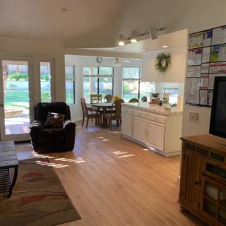 An open and airy living room with a dining area, featuring natural light and cozy furnishings.