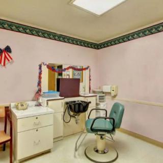 A vintage-style hair salon with a single chair and mirror, decorated with festive garlands.