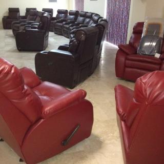 A spacious living room featuring an arrangement of red and black recliners.