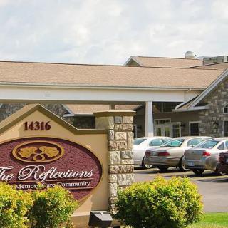 An entrance to a building with a visible sign and parked cars nearby.