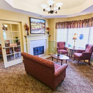 A cozy living room with a fireplace and seating area.