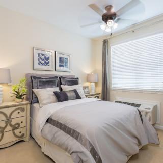 A modern bedroom with a neatly made bed, stylish furniture, and decorative elements.