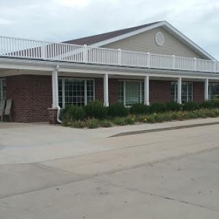 A welcoming residential building with a porch and landscaped surroundings.
