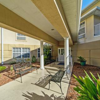 A covered outdoor walkway with benches and landscaped garden area.