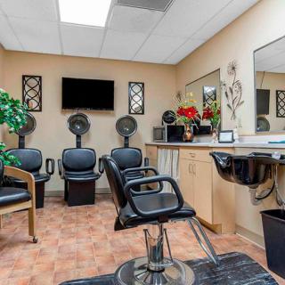 A modern hair salon featuring styling chairs, mirrors, and hair dryers.