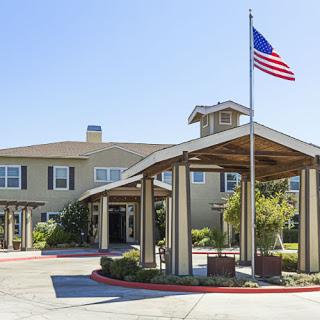 The welcoming entrance of a residential facility with an American flag.