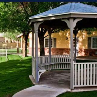A charming gazebo surrounded by lush greenery, providing a peaceful retreat in the garden.