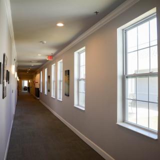 A well-lit hallway with large windows and a long corridor.