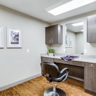 A modern hair salon interior with a styling chair and mirror.